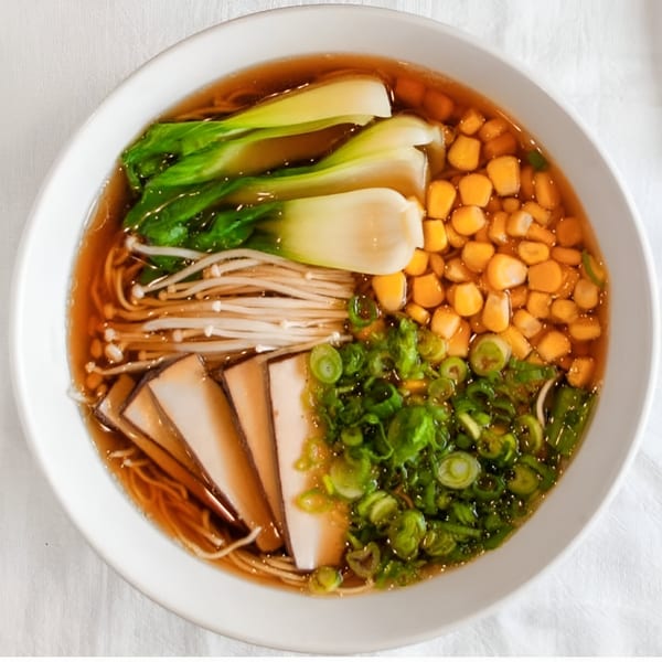 Overhead view of Motto Ramen's ramen bowl with bok choy, corn, mushrooms, and scallions.